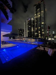 a swimming pool with a city skyline at night at Views and Vibes - Free Parking - great location! in Brisbane