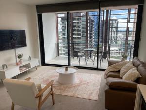 a living room with a couch and a table at Views and Vibes - Free Parking - great location! in Brisbane