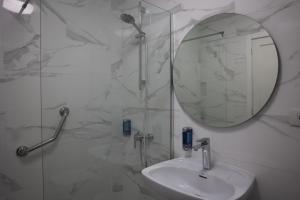 bagno con doccia, lavandino e specchio di MC Apartments a Puerto del Rosario