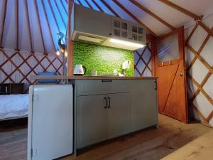 a kitchen in a yurt with a sink and a refrigerator at Jurta Na Skraju Lasu 