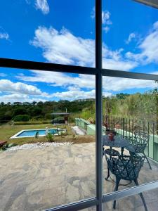 una ventana con vistas a un patio con mesa y piscina en Airb nb private rooms close to the airport Juan Santa María en Alajuela