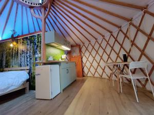 a room with a kitchen and a bed in a yurt at Jurta Na Skraju Lasu in Zawady
