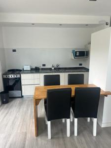 a kitchen with a wooden table and black chairs at Amar Azul in Mar Azul +10 photos