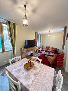 a dining room with a table and a living room at Magnifique maison entière, meublée tout confort et son jardin clos privé in Villeblevin