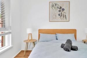 a bedroom with a bed with a stuffed animal on it at Cheltenham Delight - Renovated Two Bedroom Unit in Cheltenham