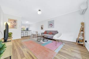 a living room with a couch and a table at Cheltenham Delight - Renovated Two Bedroom Unit in Cheltenham