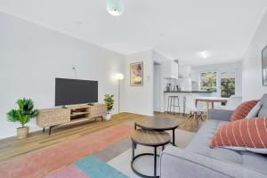 a living room with a couch and a flat screen tv at Cheltenham Delight - Renovated Two Bedroom Unit in Cheltenham