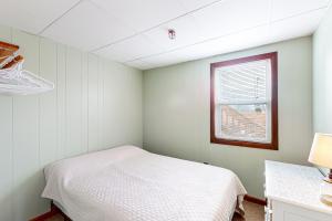 een witte kamer met een bed en een raam bij Seafoam Dreams in York