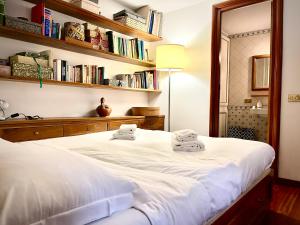 ローマにあるColosseum Luxury Apartmentのベッドルーム(白い大型ベッド、本棚付)