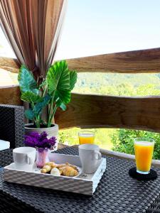 a tray of pastries and orange juice on a table at Holiday home with hot tube, near the river in Pokupsko