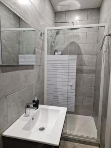 y baño blanco con lavabo y ducha. en maison individuelle à Drancy, en Drancy