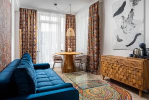 Siesta Boutique Smart Suites في كلوي نابوكا: غرفة معيشة مع أريكة زرقاء وطاولة