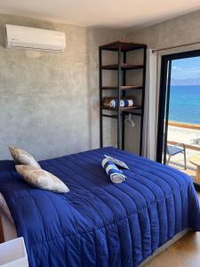 Schlafzimmer mit einem blauen Bett und Meerblick in der Unterkunft Beach Front Lofts, La Ventana in La Ventana