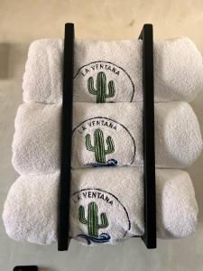 drei weiße Handtücher mit Kaktus drauf. in der Unterkunft Beach Front Lofts, La Ventana in La Ventana