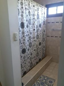 y baño con ducha y cortina de ducha. en Mi Chalet Carlos Paz - Dúplex en Villa Santa Cruz del Lago