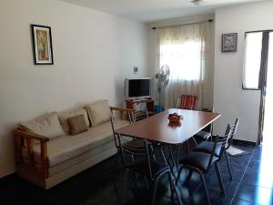 sala de estar con sofá y mesa en Mi Chalet Carlos Paz - Dúplex en Villa Santa Cruz del Lago