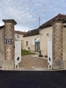 a couple of white gates in front of a house at Magnifique maison entière, meublée tout confort et son jardin clos privé in Villeblevin