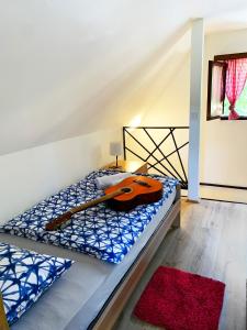 a room with a bed with a guitar on it at Holiday home with hot tube, near the river in Pokupsko