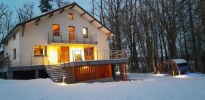 una gran casa en la nieve en el bosque en Gîte de la Ferme de Lexhy en Stavelot