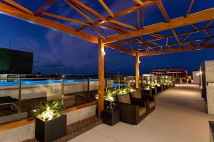 a rooftop patio with plants and lights at night at Eco Summer Tambaú - Apartamento de Alto Padrão de 2 Quartos in João Pessoa