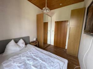 a bedroom with a white bed and a mirror at Villa Ganzstein Appartement in Mürzzuschlag