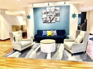 布里奇頓的住宿－MainStay Suites St Louis Airport，客厅配有两把椅子和蓝色沙发