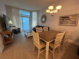 a dining room and living room with a table and chairs at 2501 S Ocean Blvd, 1215 - Ocean View Sleeps 8 in Myrtle Beach