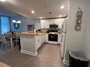 una cocina con electrodomésticos blancos y una mesa con comedor. en 2501 S Ocean Blvd, 1215 - Ocean View Sleeps 8, en Myrtle Beach