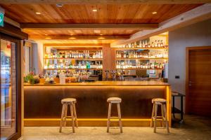 a bar with two bar stools in a room at Au Charmant Petit Lac - Ecohotel Parc & Spa in Champoluc