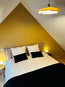 a bedroom with a large bed with two pillows at la madrague des 2 caps in Audembert