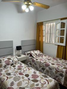 sypialnia z 2 łóżkami i wentylatorem sufitowym w obiekcie Departamento Fatima w mieście Villa Dolores