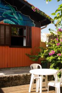 a table and chairs in front of a building at Hostel Antônio Pescador - Centro da Guarda do Embaú in Guarda do Embaú