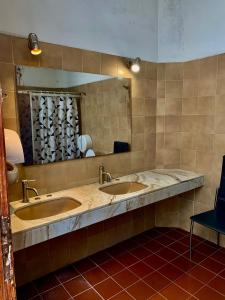 Hostel Bohemian House في مونتيفيديو: حمام مغسلتين ومرآة