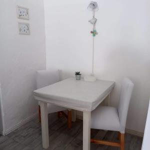 a white table and chair with a lamp on it at Alamo in Pinamar