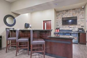 a bar in a hotel room with two chairs at a counter at Cobblestone Hotel & Suites - Mosinee in Mosinee
