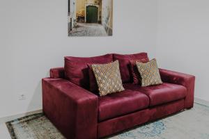 a red couch with pillows on it in a room at Apartamentos Sol & Ria in Olhão