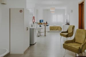 a living room with two chairs and a table at Apartamentos Sol & Ria in Olhão