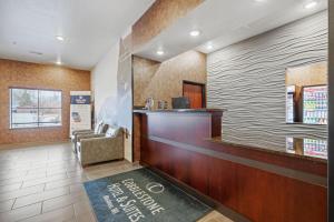 a waiting area of a hotel with a reception desk at Cobblestone Hotel & Suites - Mosinee in Mosinee