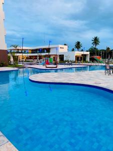una gran piscina azul frente a un edificio en Makia Beach Experience en Ipojuca
