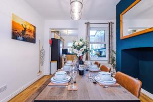 a dining room table with plates and flowers on it at NEW! Spacious 2-bed home in Chester City-Centre by 53 Degrees Property, ideal for Couples & Small groups, Great Location - Sleeps 5 in Chester