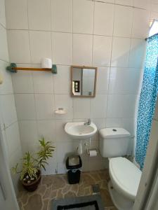 a bathroom with a toilet and a sink at Casa de Praia Suítes in Saquarema