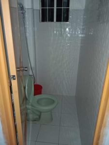 uma casa de banho com um WC verde e um chuveiro em 4jMarte Home Stay em Imus