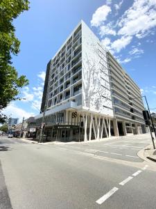 um grande edifício branco numa rua com uma estrada em Premium Apartments Chatswood em Sidney