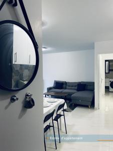 sala de estar con sofá y espejo en Appartement parisien 56 m2 neuf, moderne avec 2 chambres, 4 lits, parking gratuit, 15min de Paris et 13 min aéroport Orly en Vitry-sur-Seine