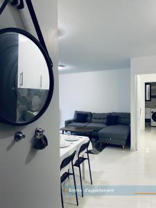a living room with a couch and a mirror at Appartement parisien neuf, moderne avec une grande salon, 2 chambres, 3 lits, parking gratuit, 15min de Paris et 13 min aéroport Orly in Vitry-sur-Seine