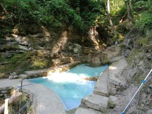 una pequeña piscina de agua azul en una colina rocosa en Il Rifugio Di Artemide AGRITURISMO, en Perinaldo