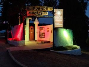 un pequeño edificio se ilumina por la noche en Hotel Boutique El Duende Mantagua en Quintero