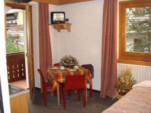 comedor con mesa, sillas y TV en Hotel Derby, en Bormio