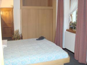 1 dormitorio con cama, ventana y cortinas en Hotel Derby, en Bormio