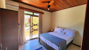 a bedroom with a bed and a large window at Partiu Praia SC piscinas privativas, ar condicionado, internet, próximo ao mar e centrinho três minutos a pé in Guarda do Embaú